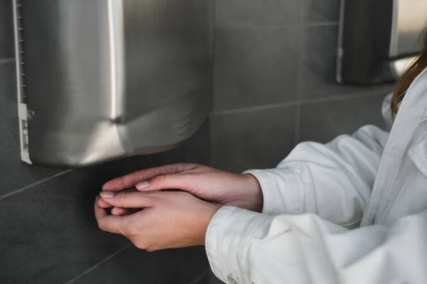 Person Drying Their Hands Under a Automatic Hand Dryer